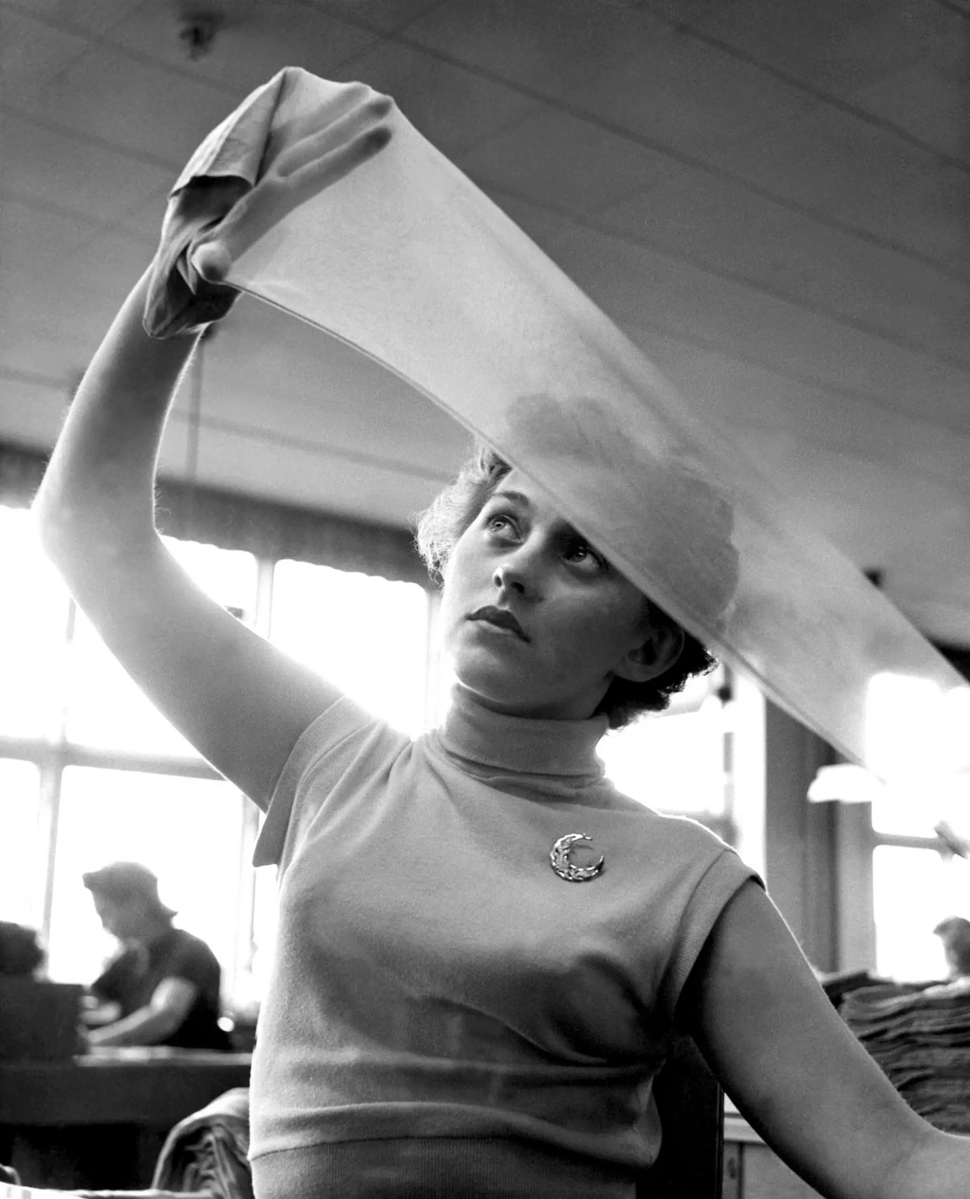 Picture of a factory worker examining nylon stockings