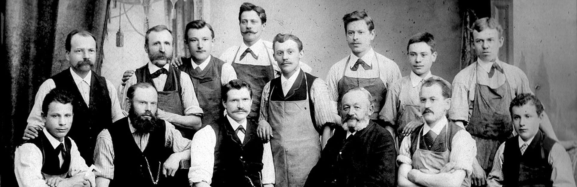 A group of men pose for a black and white photo from 1888